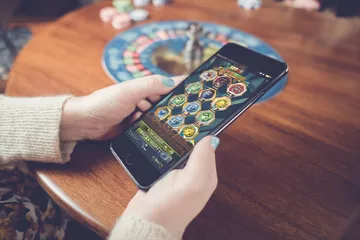 A man focused on his laptop with live stats in the background, highlighting the dedicated sports and gaming features of the 866JL mobile app.